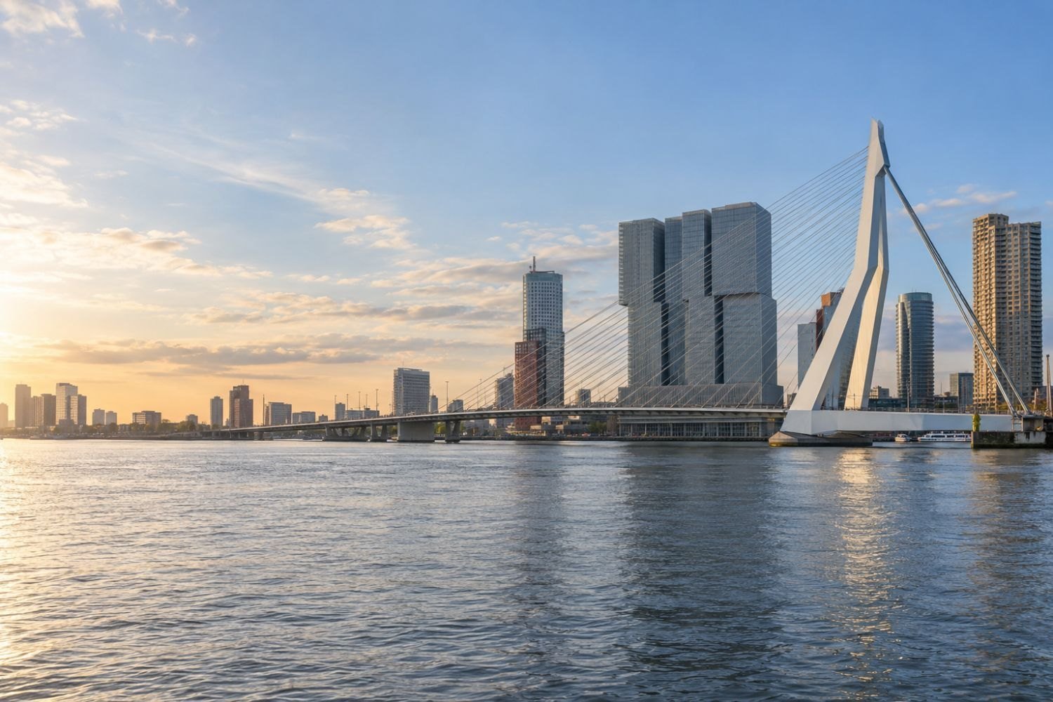 De Erasmusbrug en de skyline van Rotterdam bij zonsopkomst, gezien vanaf de Maas